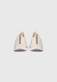 Sneakers with a cream upper, light purple accents, and a textured rubber sole. Features a pull tab at the heel and cushioned support.