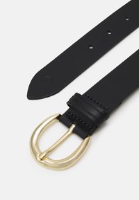 Ceinture en cuir noir avec une boucle en métal doré, design plat avec plusieurs trous d'ajustement, texture lisse et extrémité arrondie.