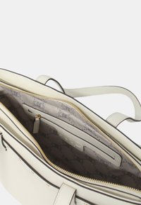 Borsa a mano in pelle bianca con zip dorata, dotata di foderatura grigia a motivo e tasca interna. Include due robusti manici.