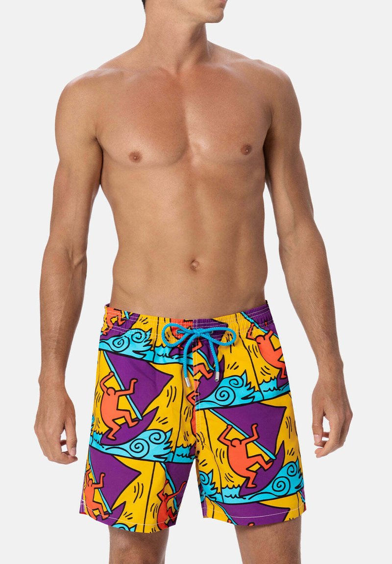 Costumi da bagno realizzati in tessuto elasticizzato; giallo vivace con motivi astratti blu e arancioni che raffigurano figure e onde; vita con cordoncino.