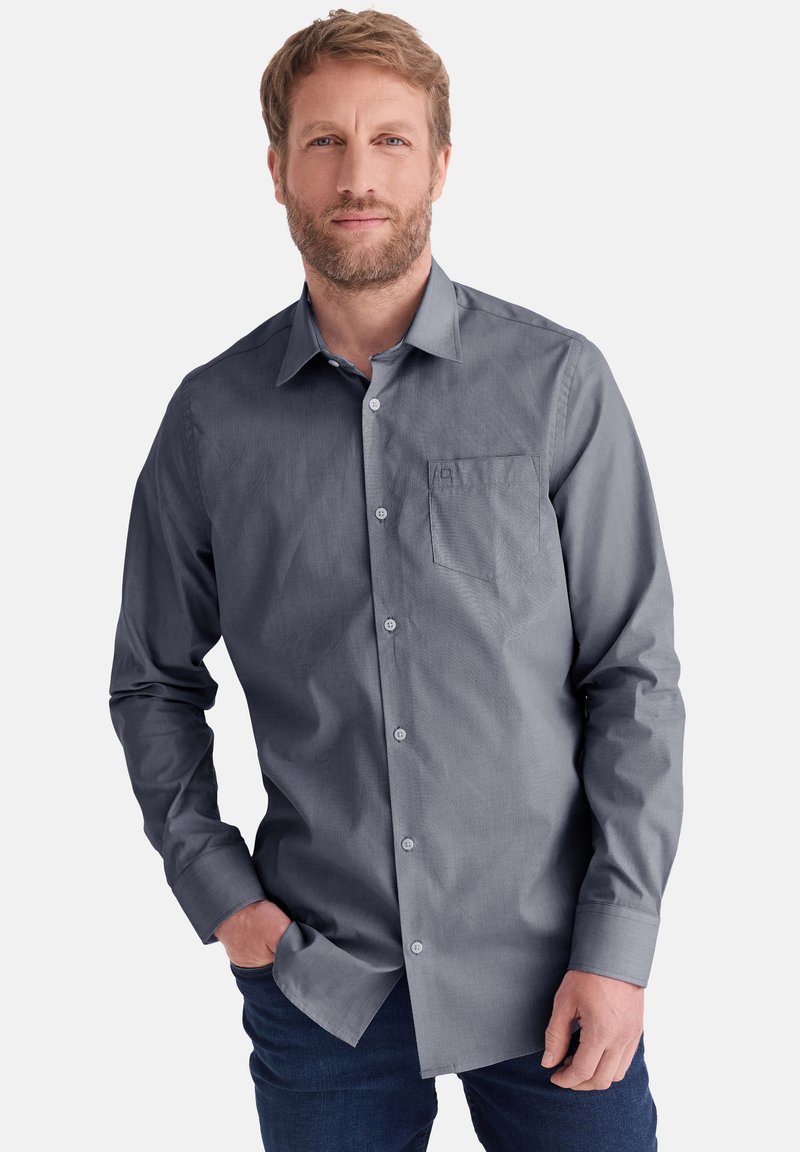 Grau button-up Hemd mit langen Ärmeln, klassischem Kragen, Brusttasche und strukturiertem Stoff; getragen mit Händen in den Taschen, kombiniert mit Jeans.