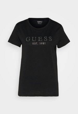 T-shirt en coton noir avec des manches courtes, un col rond et un design à l'avant avec "GUESS" et "EST. 1981" en accents cloutés.