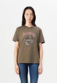 Olivenfarget t-skjorte med rund hals og korte ermer, med et sølv- og rødt liongrafikk og "Joop! Jeans"-tekst på brystet.