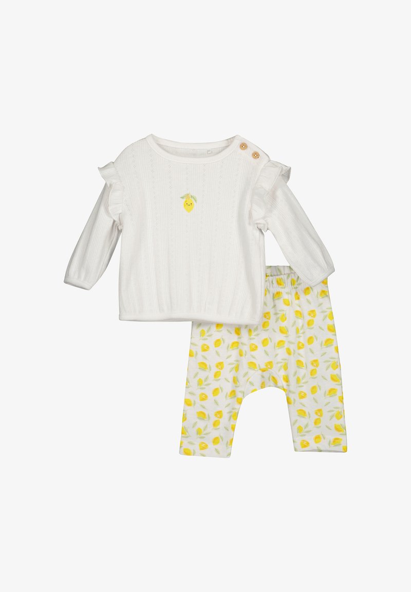 Biała bluzka z długim rękawem z falbankami na rękawach i haftem cytryny; żółte spodnie w wzór cytryn; miękki bawełniany materiał, casualowy design.
