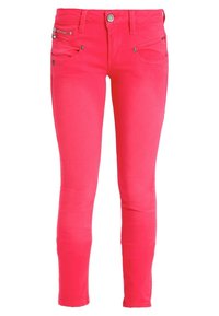 Jeans ajustados de un brillante color rosa, con botón frontal, cierre de cremallera, lazos para cinturón y múltiples bolsillos, incluyendo un pequeño bolsillo con cremallera.