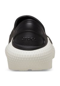 Czarne klapki Crocs z gładką górą i białą, teksturowaną podeszwą z wypukłymi kropkami. Nazwa modelu "crocs" wytłoczona na pięcie.