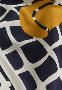 Silk fabric with a navy blue and cream grid pattern. Features a large mustard-colored abstract shape. Smooth texture and lightweight design.