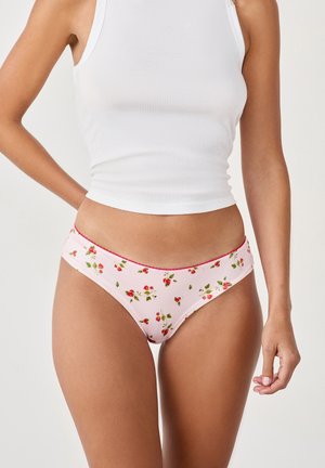 Slip bikini floreale rosa con un motivo di piccole fragole e foglie verdi. Presenta cuciture rosse a contrasto lungo l'elastico in vita.