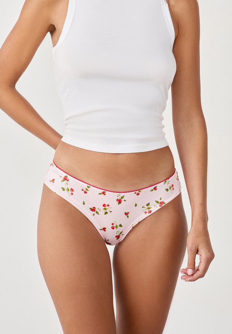 Rosa Blumenslip-Bikini mit einem Muster aus kleinen Erdbeeren und grünen Blättern. Verfügt über kontrastierendes rotes Nähen entlang des Taillenbunds.