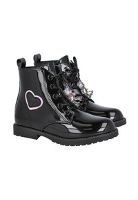 Botines de charol negro con cordones decorativos transparentes, parche de purpurina rosa en forma de corazón y suela de goma texturizada.