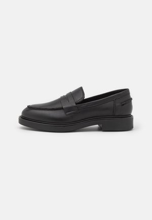 Mocassins en cuir noir avec un bout arrondi, dotés d'une accentuation en couture sur le devant et d'un talon bas en bloc pour la stabilité.