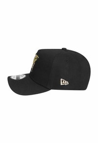 Schwarze Baseballmütze mit gebogenem Schirm, die an der Vorderseite ein goldfarbenes gesticktes Design und an der Seite ein kleines cremefarbenes Logo aufweist.