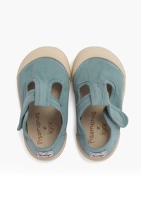 Helle teal Canvas-Schuhe mit runder Zehenpartie, die über Aussparungen und eine kleine Schleife an der Seite verfügen. Beigefarbene Gummisohlen runden das Design ab.