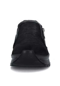 Scarpa nera slip-on con tomaia strutturata, punta liscia e suola in gomma con un leggero tacco. Include un dettaglio con zip laterale.