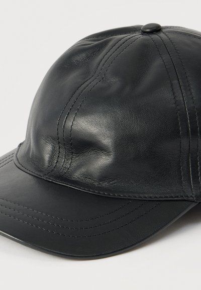 Μαύρο δερμάτινο καπέλο με στρογγυλεμένο στέμμα, ραμμένες λεπτομέρειες και καμπύλη γείσο. Λείο υφή με γυαλιστερό φινίρισμα.