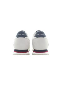 Încălțăminte sport cu un superior gri neted, cu accente din plasă și un contrafort al călcâiului de culoare albastră, talpă albă și dungi roșii și bleumarin pe talpa intermediară.