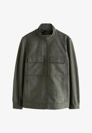 Olivgrüne Jacke mit Reißverschluss auf der Vorderseite, ausgestattet mit zwei aufgesetzten Taschen, gerippten Bündchen und kontrastierendem Stoff an den Ärmeln, aus einem weichen Material gefertigt.