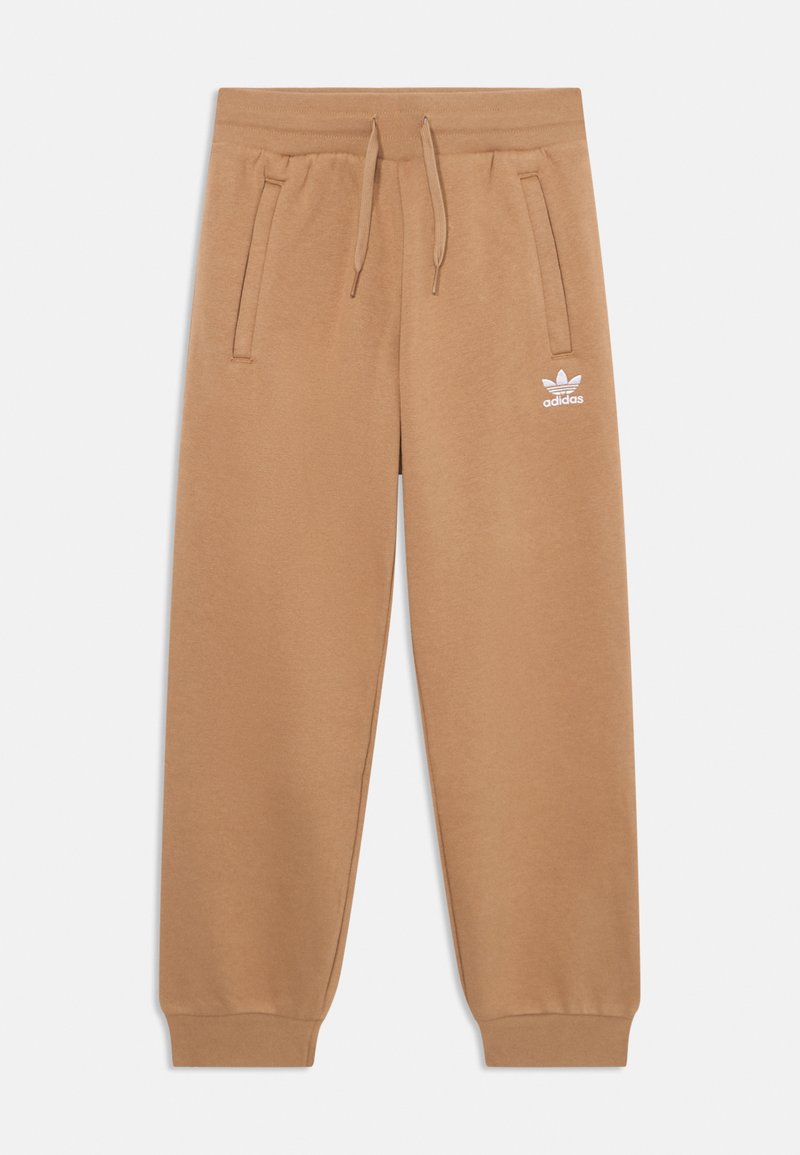 Beige trenirke iz mehkega blaga, z elastičnim pasom in vrvico, stranskimi žepi ter belim logotipom na levem stegnu.