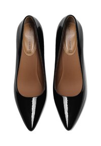 Zapatos de tacón de charol negro con diseño de punta afilada y un acabado suave y brillante. El interior cuenta con un forro de piel marrón.