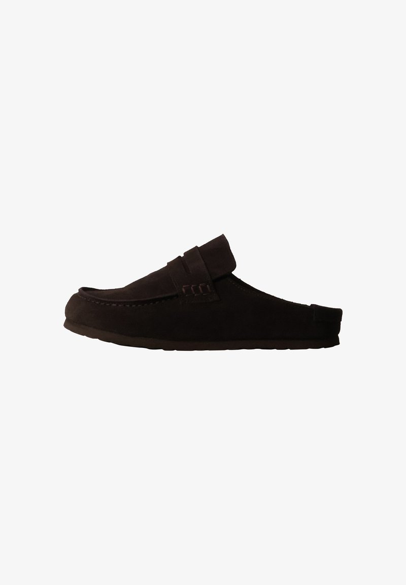 Chaussure style mocassin marron foncé à enfiler avec semelle plate et détail cousu sur la tige, présentée en profil sur fond blanc.