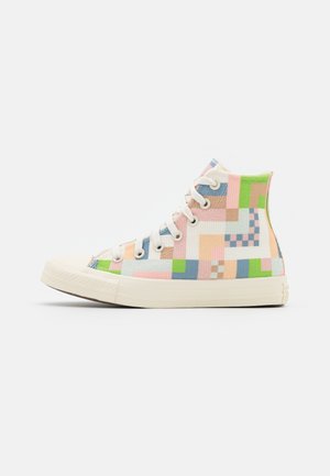 Hoge canvas sneaker met witte zool en veters, voorzien van een pastel geometrisch patroon in groene, roze, blauwe en beige blokken.