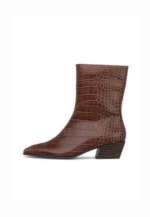 Bota marrón a mitad de la pantorrilla con puntera puntiaguda, textura de cocodrilo y tacón apilado bajo en acabado de madera oscura.