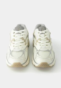 White mesh sneakers with light beige and silver accents. Features textured panels, lace-up closure, and a cushioned sole for comfort.