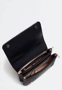 Sort læderhåndtaske med en tekstureret overflade. Indvendigt har den to lynlåslommer og en trykknaplukning. Accentueret med metal i guldfarve.