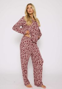 Bordeaux pyjama set met een luipaardprint, lange mouwen, loszittende broek en een zachte, lichte stof.