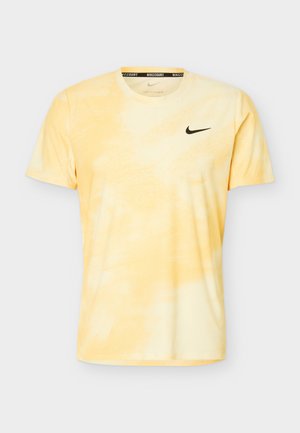 Ανδρική κοντομάνικη μπλούζα Nike Dri-FIT σε ανοιχτό κίτρινο με διακριτικό σχέδιο tie-dye και μαύρο λογότυπο Nike στο στήθος.