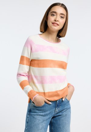 Gestreepte trui in crème, roze en oranje. Met ribbelmanchetten en -zoom, ronde halslijn en lichte zijsplitten. Gecombineerd met blauwe denim.