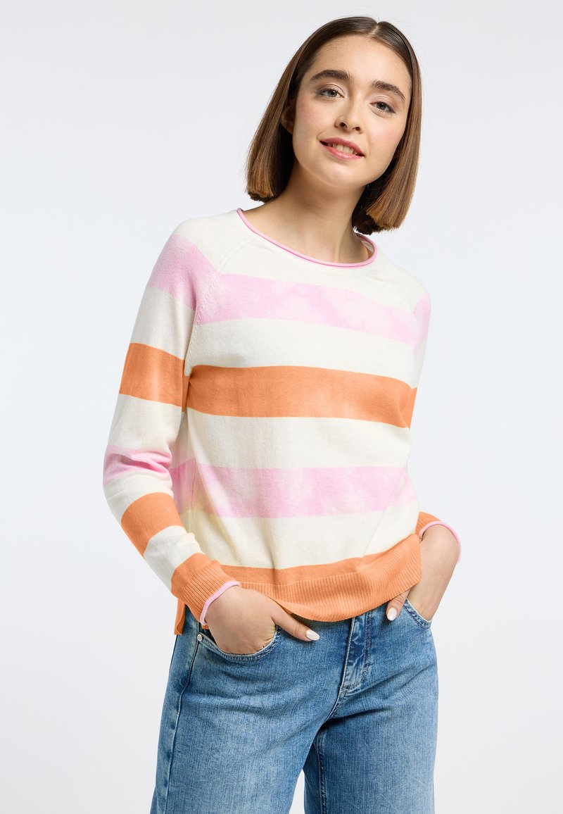 Gestreepte trui in crème, roze en oranje. Met ribbelmanchetten en -zoom, ronde halslijn en lichte zijsplitten. Gecombineerd met blauwe denim.