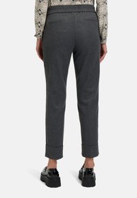 Graue maßgeschneiderte Hose mit weicher Textur, elastischem Bund und umgeschlagenen Säumen. Verfügt über zwei Gesäßtaschen und ein schmales Design.