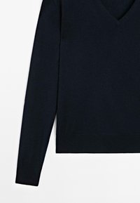 Maglione blu navy con scollo a V e maniche lunghe, posizionato in piano su uno sfondo bianco. Stile semplice e casual.