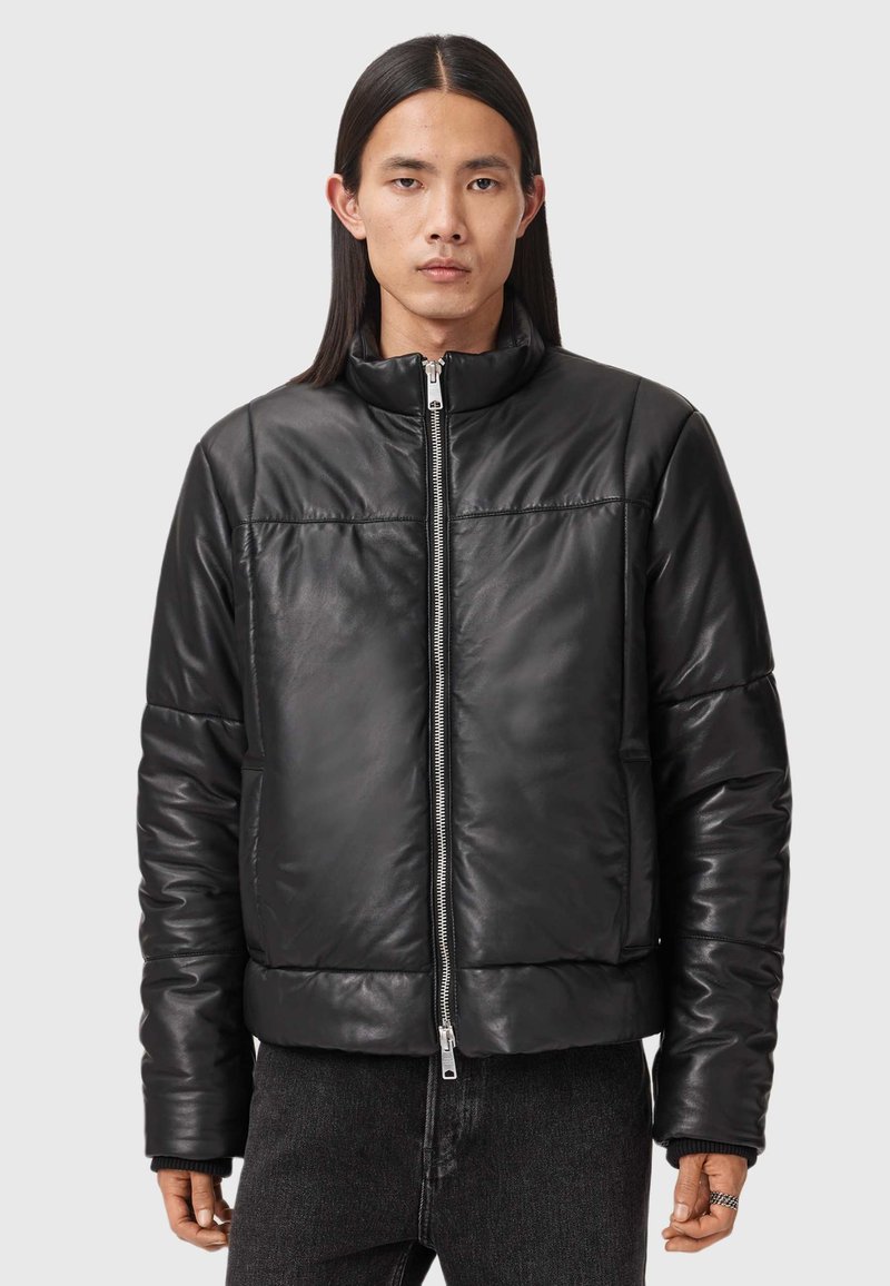 Sort læderjakke med høj krave, polstret design og frontlynlås. Har diskret syninger og en cropped silhuet.