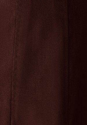 Pruun kangas tekstuurse kudumisega, nähtavate õmblustega ja siledast viimistlusest, esitleb sügavat ja rikkalikku värvi ning ühtlast tooni.