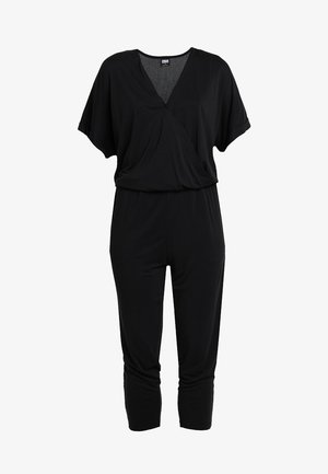 Mustaline mustade lühikeste varrukatega kombekas V-kaelusega ja vöökoha rõhutatult. Valmistatud pehmest ja venivast materjalist, omab lõdva lõiget ja lühikesi jalgu.