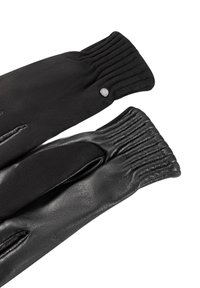 Schwarze Handschuhe aus einer Mischung aus strukturiertem Wolle und glattem Leder, mit gerafftem Detail am Handgelenk und einem silbernen Druckknopf-Akzent.