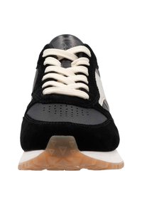 Zwarte en grijze sneaker met een textuur van nubuck en mesh bovenkant, crèmekleurige veters, geperforeerde neus, en een lichte rubberen zool met looppatronen.