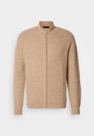 Beige bordás kötött pulcsi magas gallérral és elülső cipzárral. Hosszú ujjú, laza szabással készült, puha, textúrált anyagból.