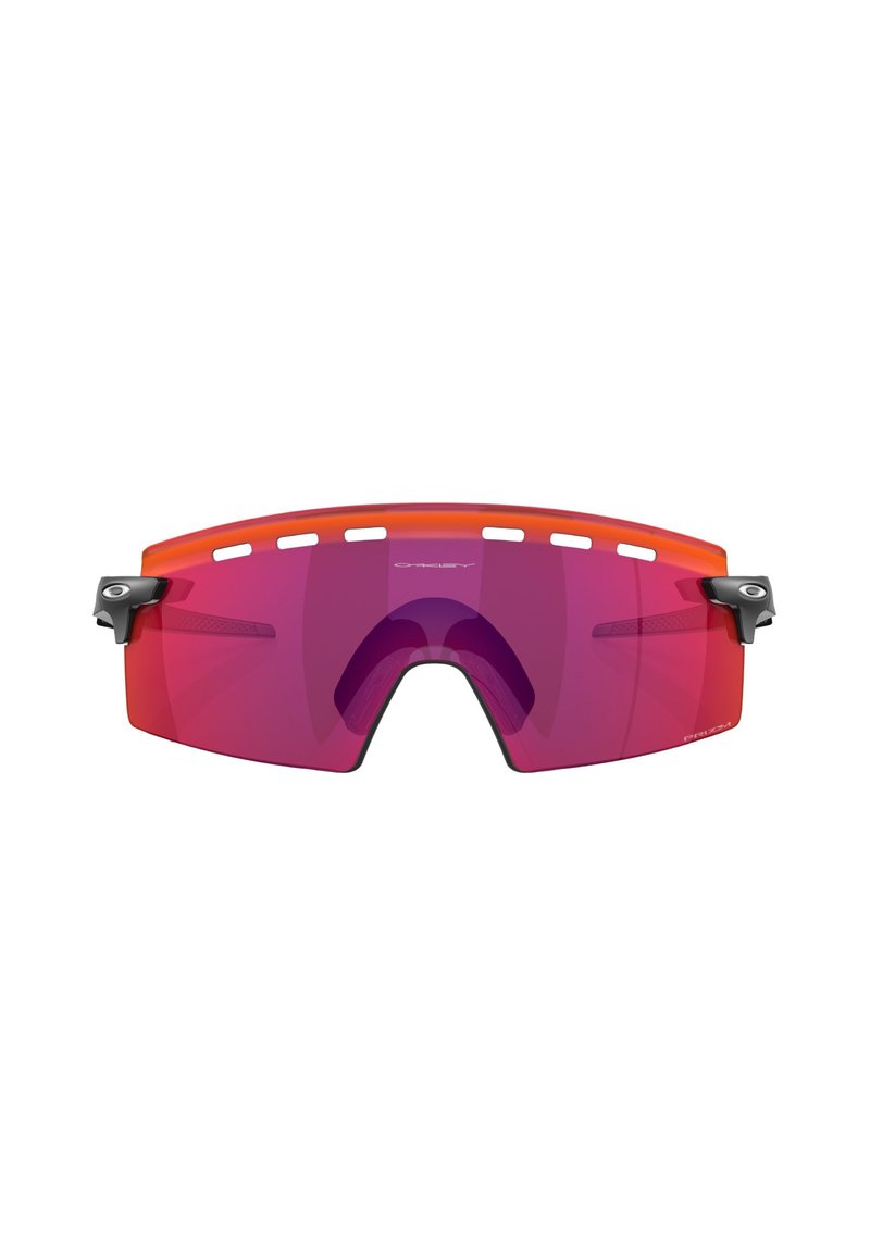 Occhiali sportivi avvolgenti con montatura arancione e lenti viola. Presentano dettagli neri e slot di ventilazione lungo la parte superiore.
