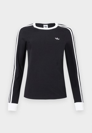 Čierna košeľa s dlhým rukávom, bielym golierom a manžetami, bielymi pruhmi pozdĺž rukávov a malým bielym logom Adidas na ľavej hrudi.