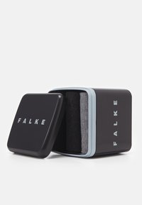 Caja de almacenamiento rectangular negra con acentos en azul claro, que presenta el texto "FALKE". Contiene dos pares de calcetines en gris oscuro y gris medio.