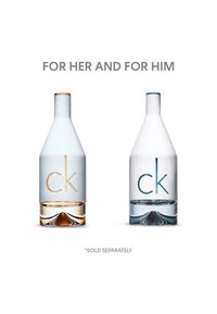 Deux flacons de parfum côte à côte. À gauche : blanc givré avec des accents dorés, base transparente. À droite : blanc givré avec des accents bleus, base transparente.