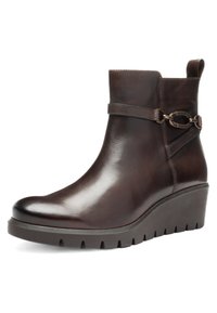 Donkere bruine leren enkellaars met sleehak, zijriem en metalen gespsdetail, en een trekband aan de achterkant.