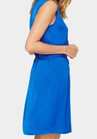 Abito blu senza maniche realizzato in tessuto leggero, con vita aderente e gonna fluente, senza motivi o dettagli visibili.