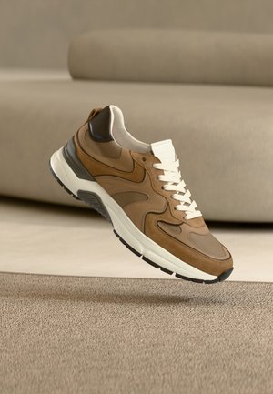 Brun sneakers med blandede materialer: læder, ruskind og mesh. Hvide snørebånd og mellemsål; sort ydersål med tekstureret greb. Rundet tådesign.