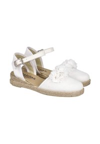 Zapatos espadrilles blancos con parte superior de tela texturizada, correas ajustables en el tobillo y un acento floral en la parte delantera sobre una suela de yute.