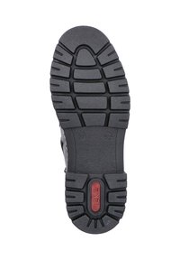 Zwarte rubberen zool met gestructureerde grippatronen, met een centraal rood logo. De zool is gebogen met ronde randen voor flexibiliteit.
