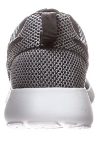 Black and gray athletic shoe with a knitted mesh upper, padded collar, and a white rubber sole. Pull tab at the heel for easy wear.